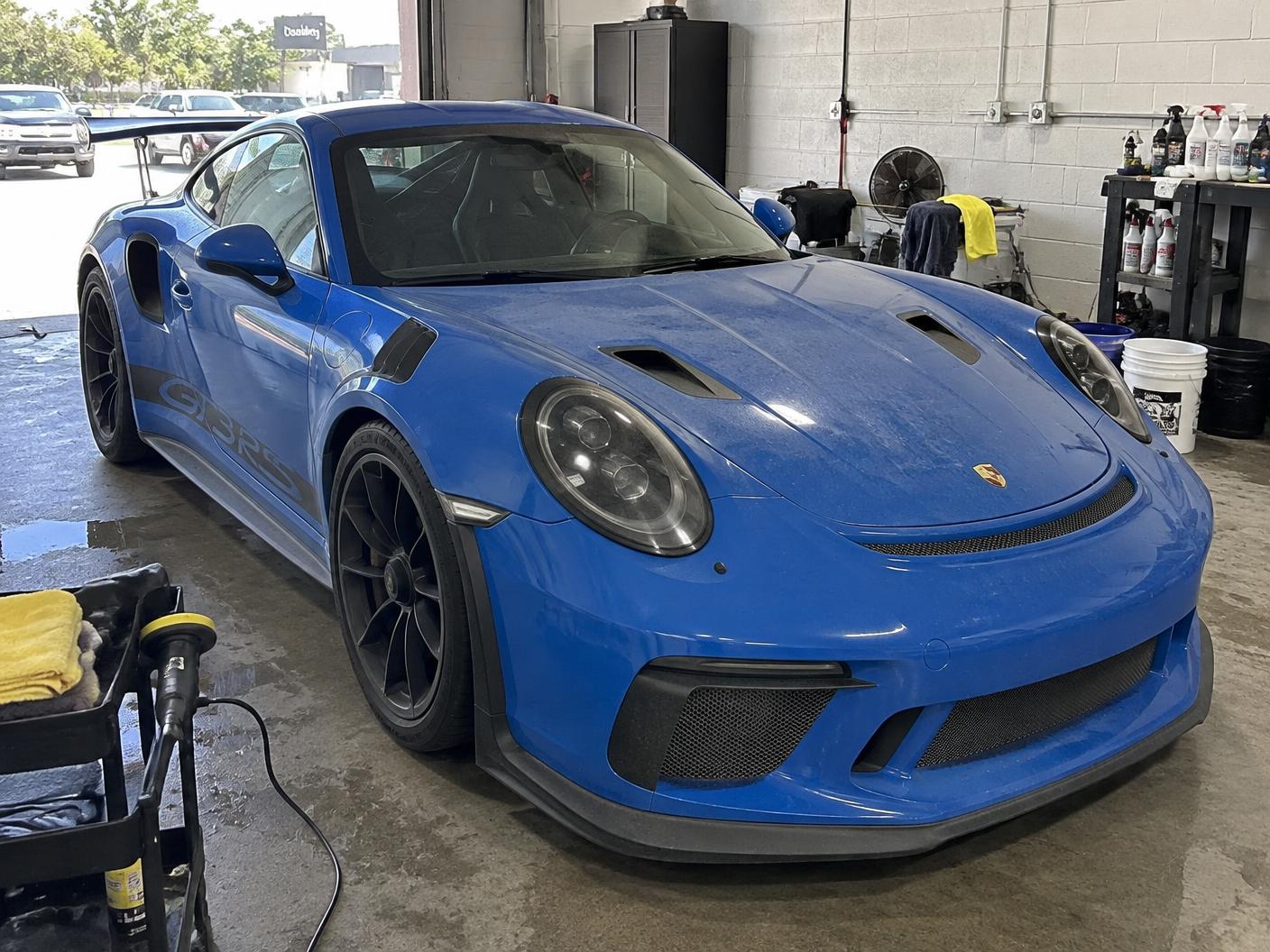 Blue Porsche 911 GT3 RS in the shop before ceramic coating with dull, dusty paint