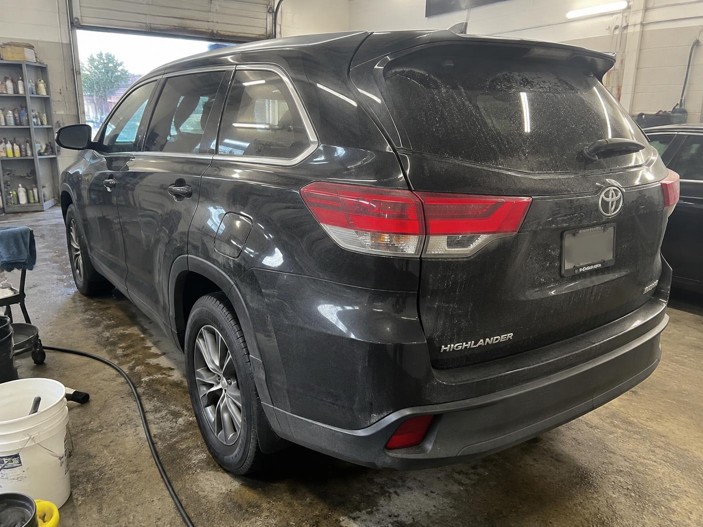 Black SUV before ceramic coating with road film, dust and water spots