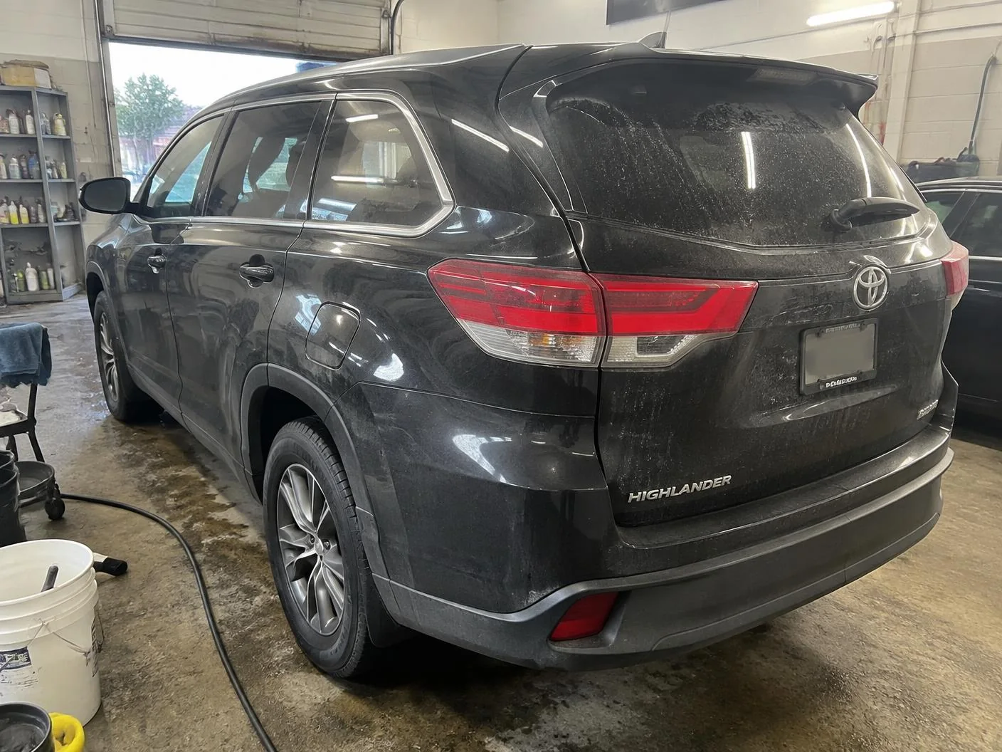 Black SUV before ceramic coating with road film, dust and water spots