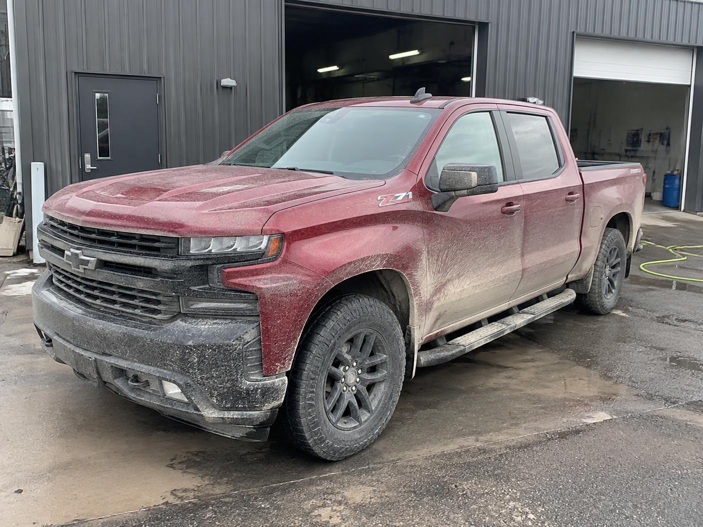 Dark red pickup truck before exterior detailing with mud, dust and road buildup