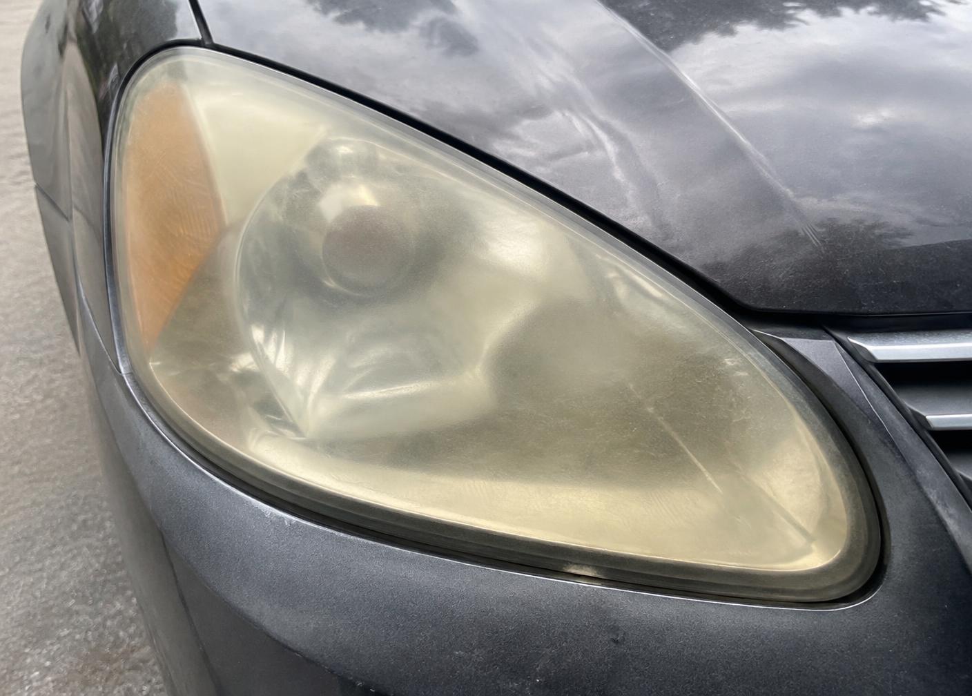 Cloudy yellow automotive headlight before restoration